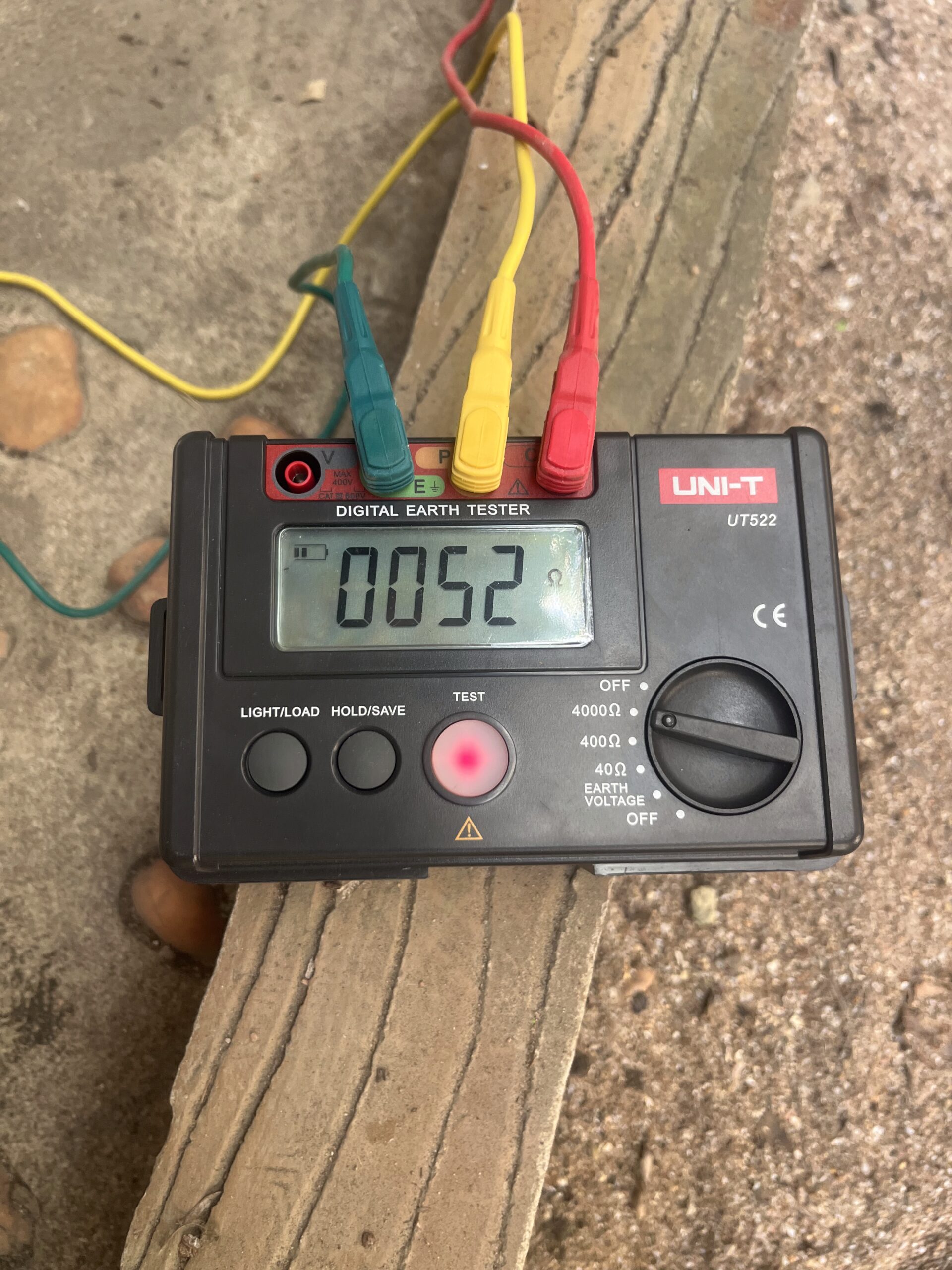 ACES Pattaya electrical technician conducting digital earth grounding resistance test with multi-color test leads