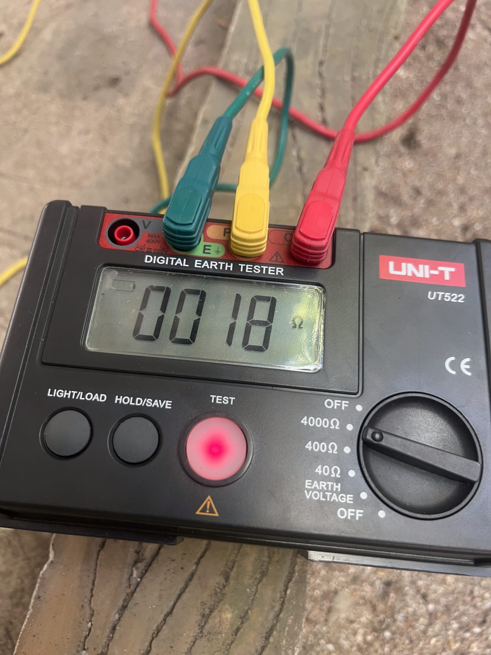 ACES Pattaya electrical technician conducting digital earth resistance and continuity testing with color-coded test leads