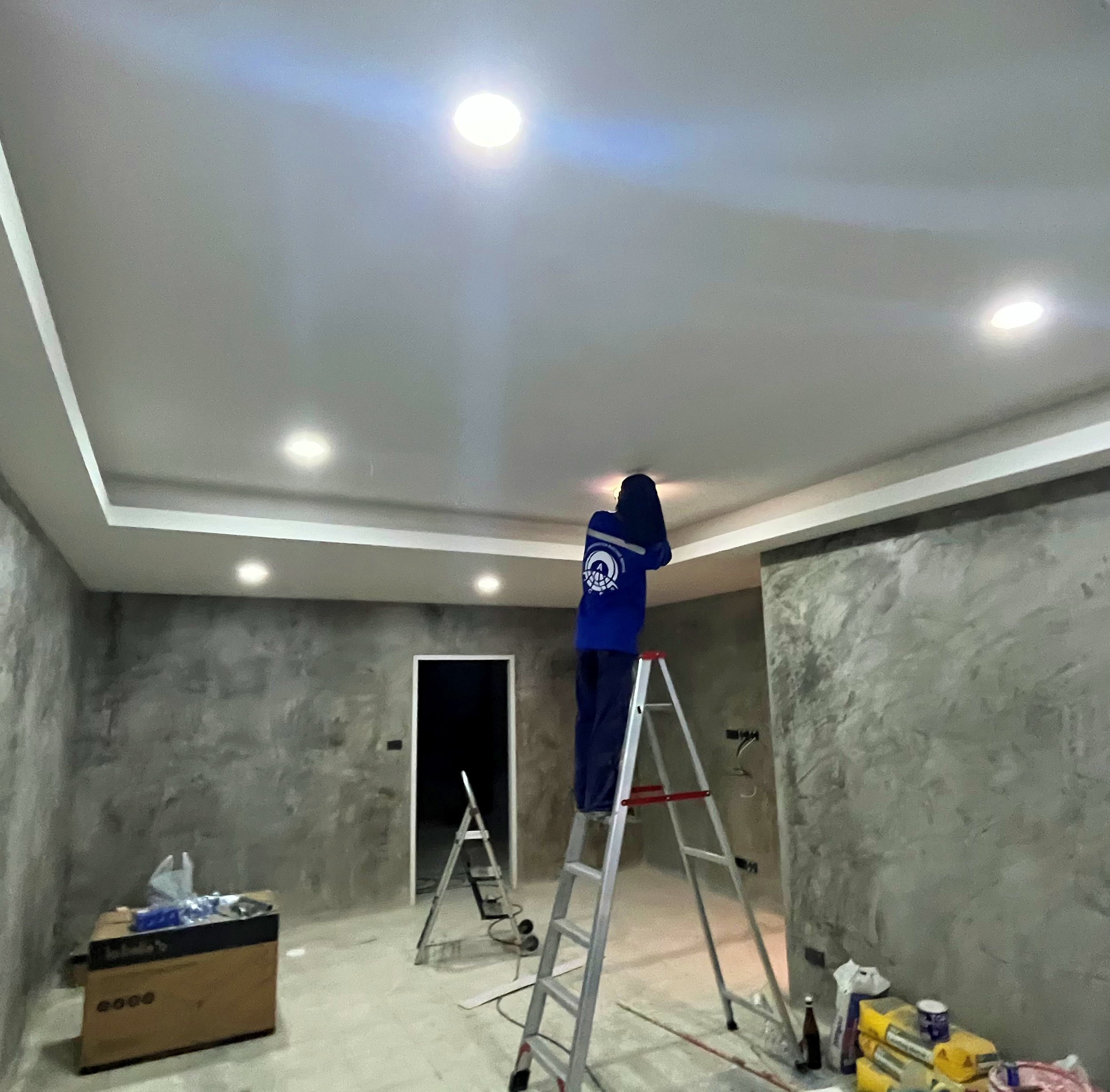 ACES Pattaya electrical technician installing recessed LED downlights and perimeter cove ceiling lighting during interior refurbishment