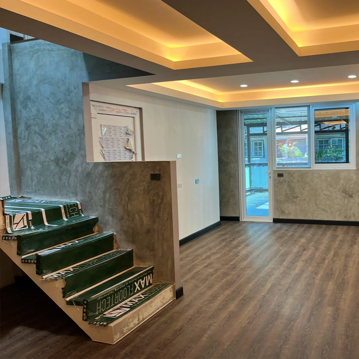 ACES Pattaya residential interior construction and turnkey renovation showing finished wood flooring, textured walls, and warm ceiling cove lighting