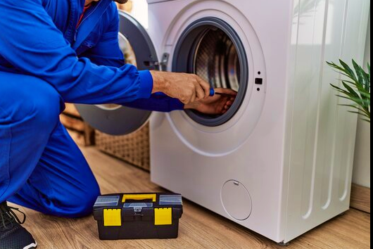 ACES technician repairing and servicing a residential front-loading washing machine drum in Pattaya