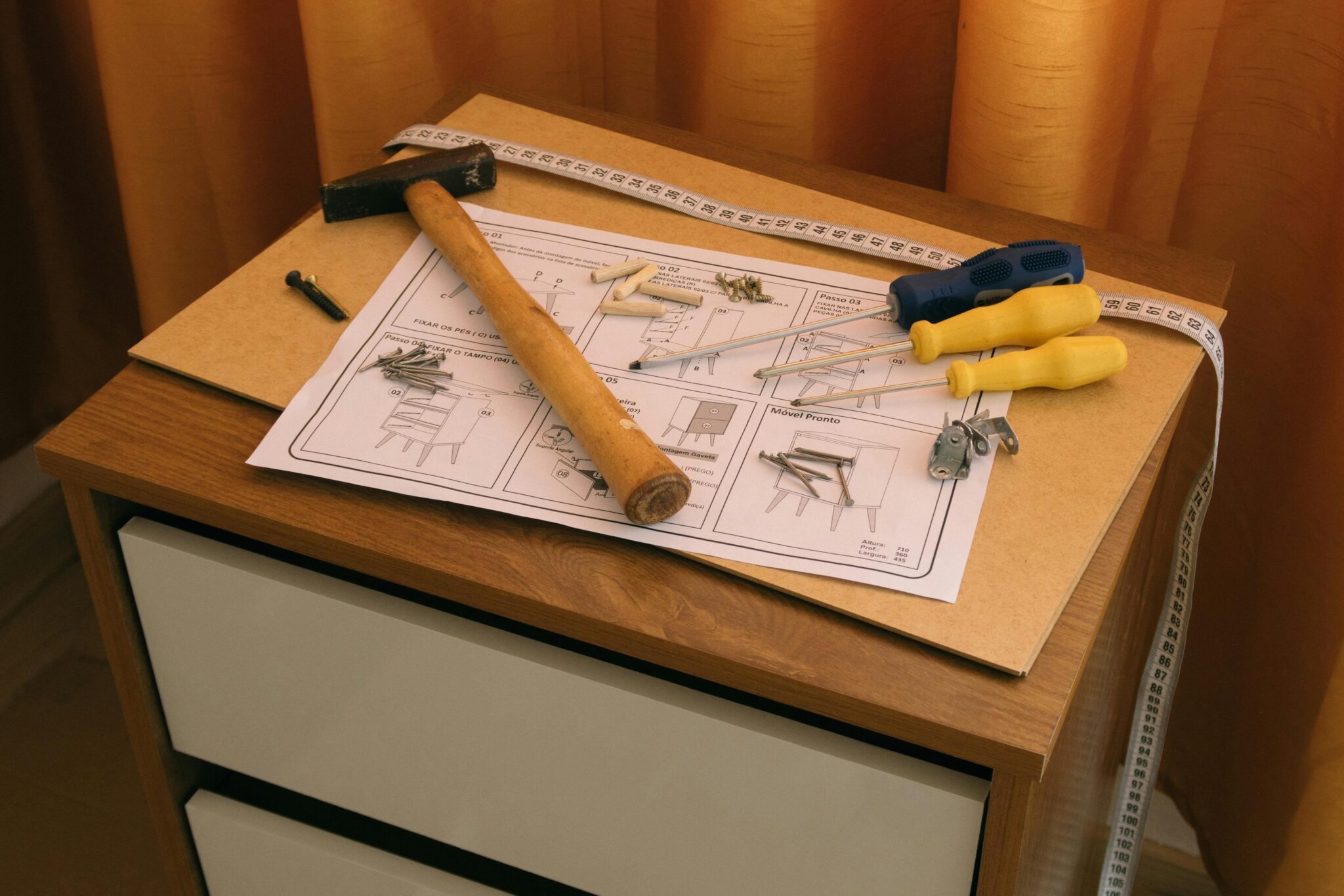 Tools and assembly instructions laid out on a wooden cabinet