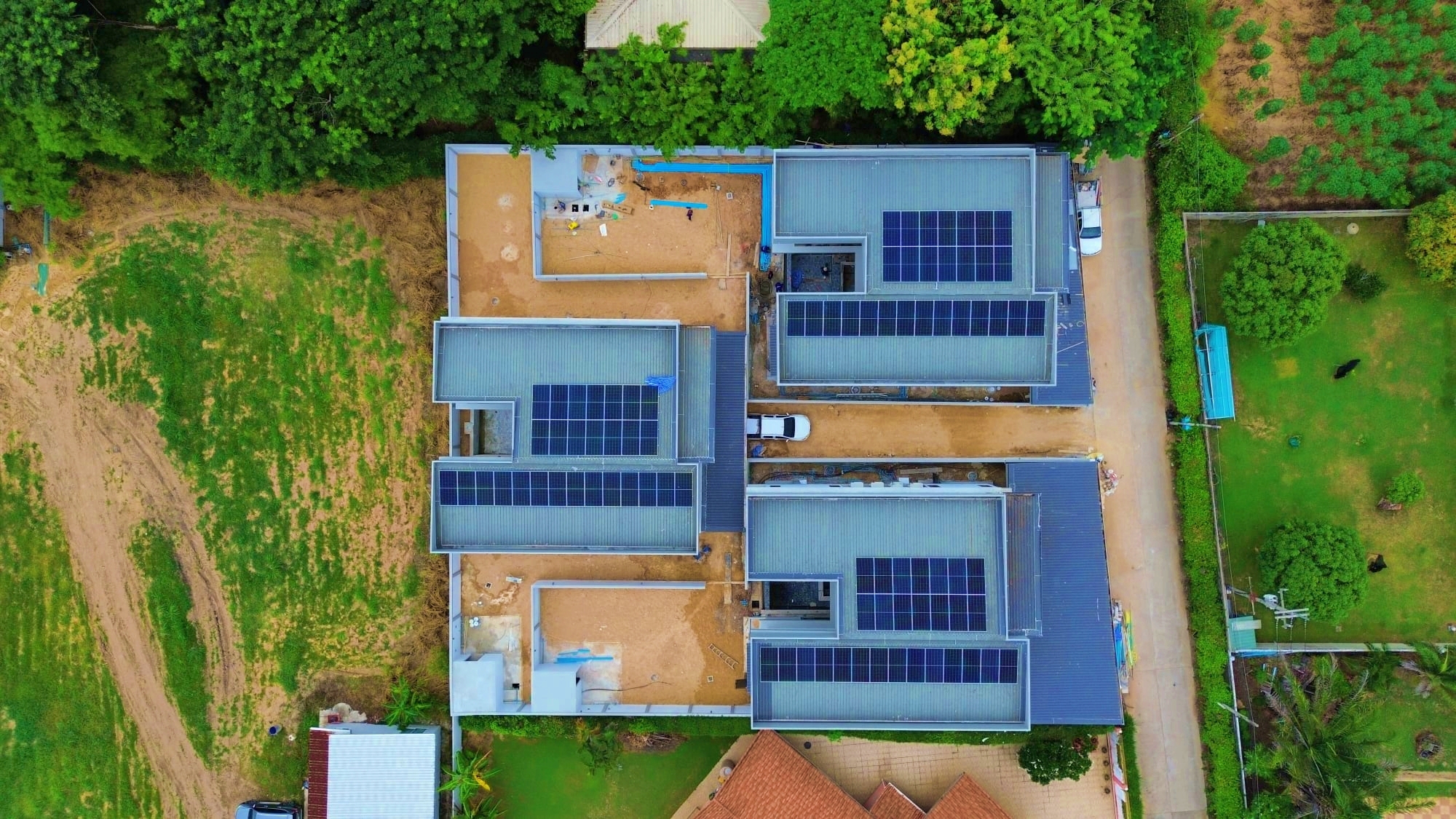Aerial drone view of a fully operational, multi-roof residential solar installation in Pattaya.