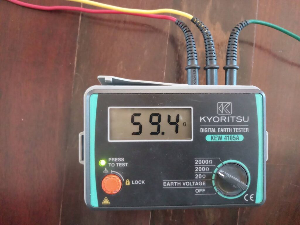 A Kyoritsu KEW 4105A digital earth ground tester displaying a dangerously high resistance reading of 59.4 Ohms during a safety inspection in Pattaya.