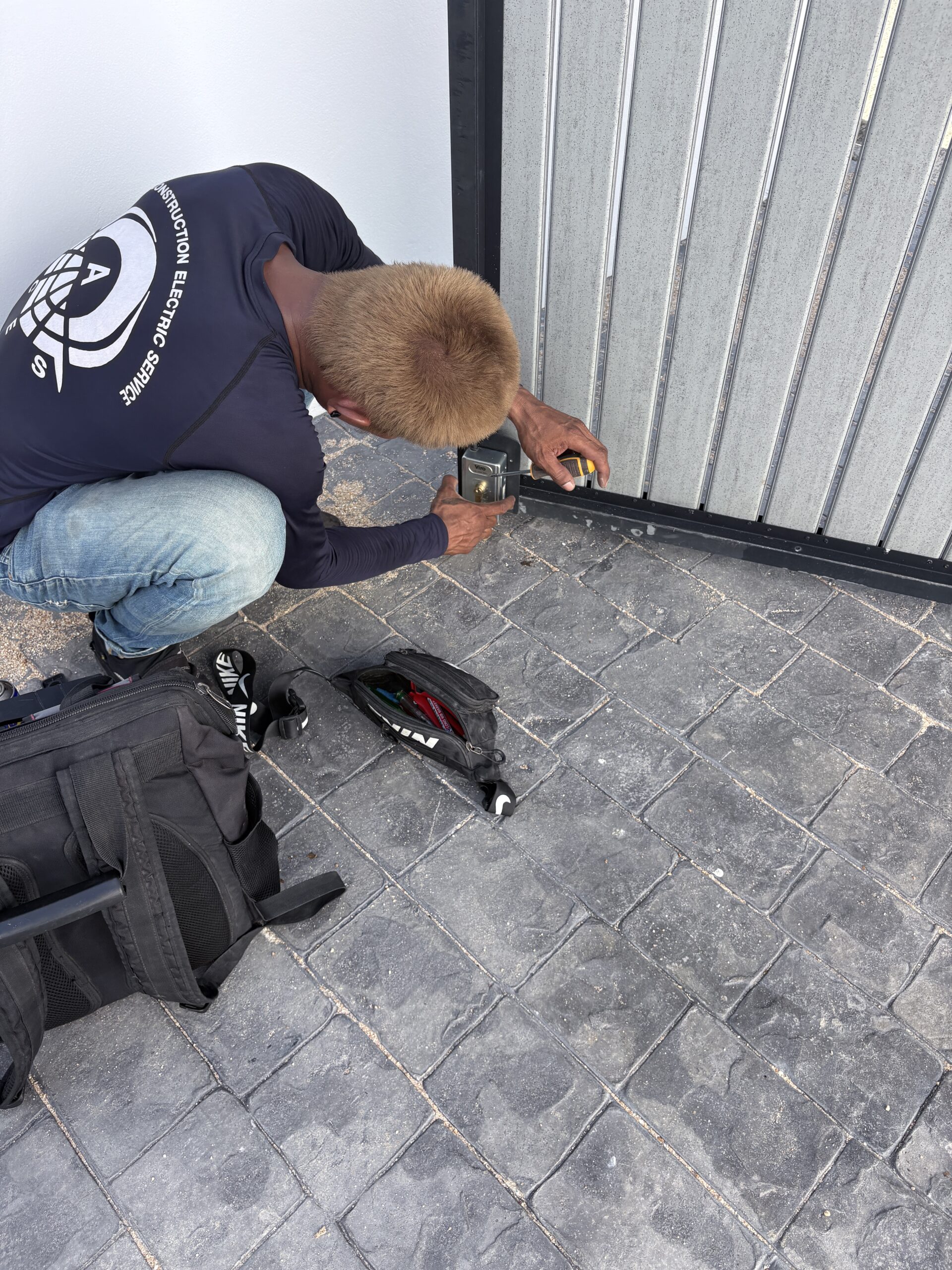 ACES technician repairing an automatic gate electronic lock mechanism in Pattaya