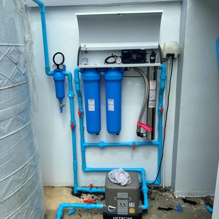Complete residential 3-stage UV water filtration system integrated with a Hitachi water booster pump and domestic storage tank by ACES Pattaya.