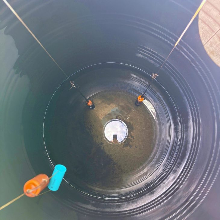 ACES technician inspecting empty residential water storage tank and failed well pump float switch in Pattaya